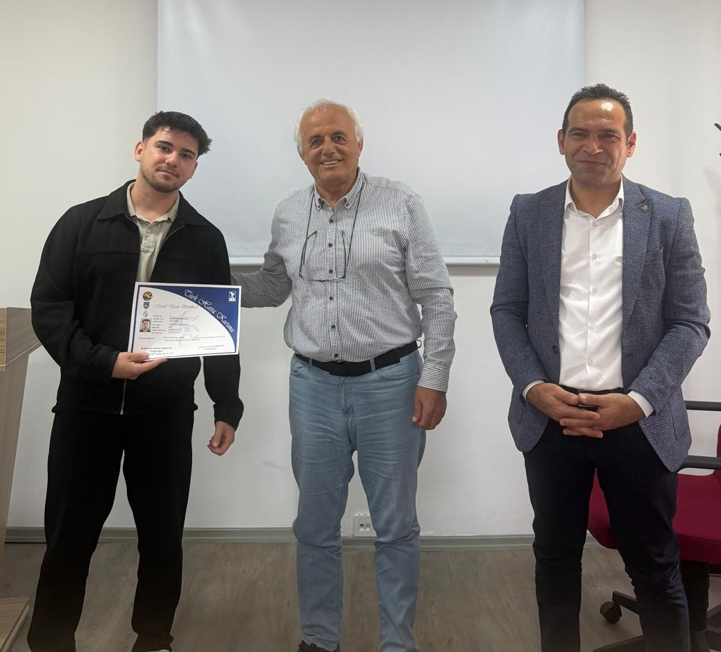 Cengiz Şatır, erkek bir öğrenciye sertifikasını verirken çekilmiş bir kare. Doç. Dr. Ozan Kaya da yanlarında eşlik ediyor.